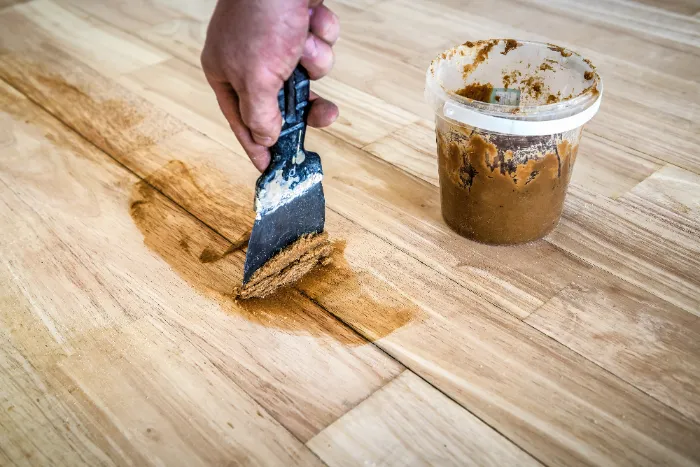filling gaps in wood floor with a spatula